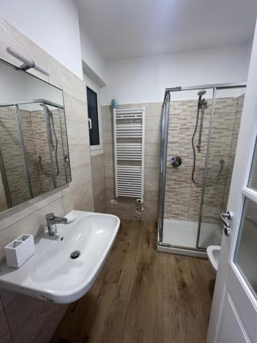 uma casa de banho com um lavatório e um chuveiro em BikeandClimb B&B em Finale Ligure