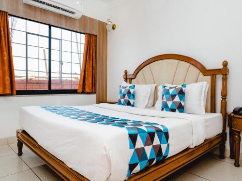 a bedroom with a large bed with a large window at Hotel Galaxy Opp Surat Railway Station in Surat