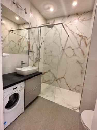 a bathroom with a sink and a washing machine at Nadmotławie Apartament with RENT Motor Boat in Gdańsk