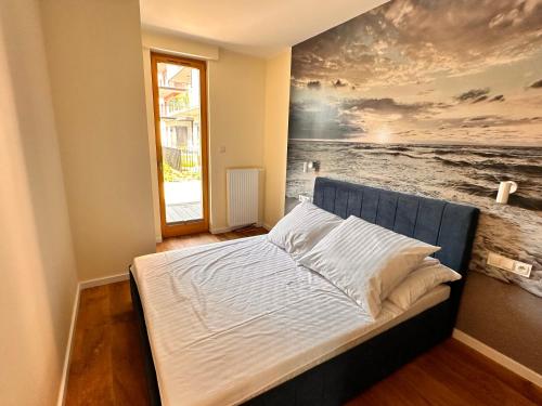 a bedroom with a bed with a painting on the wall at Nadmotławie Apartament with RENT Motor Boat in Gdańsk