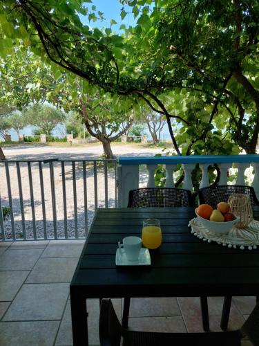 a black table with a bowl of fruit and a glass of orange juice at Apartman Lucija in Seline