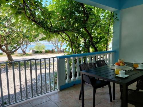 a table on a balcony with a view of the ocean at Apartman Lucija in Seline