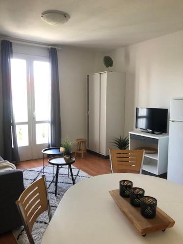 ein Wohnzimmer mit einem Tisch und Stühlen sowie eine Küche in der Unterkunft Karina Apartments in Supetar