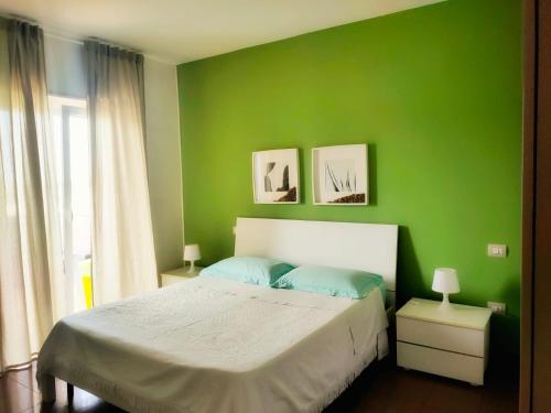 una camera verde con un letto e una parete verde di Il Mare di Giò a Monopoli