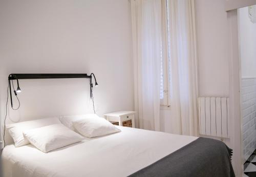 una camera con letto bianco e testiera nera di MEZZANINE YELLOW a Madrid