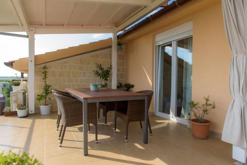 a wooden table and chairs on a patio at Sunset zadar in Zadar