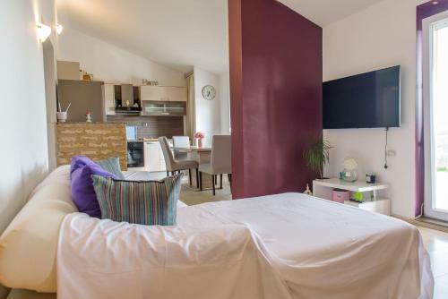 a living room with a white couch and a kitchen at Sunset zadar in Zadar