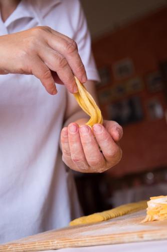 a person holding a piece of pasta in their hand at Casa Di Mi in Serrungarina