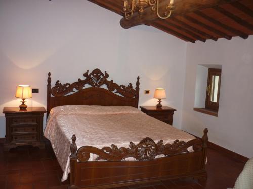 a bedroom with a large wooden bed with two lamps at La Valle dei Gobbi in Monsummano Terme