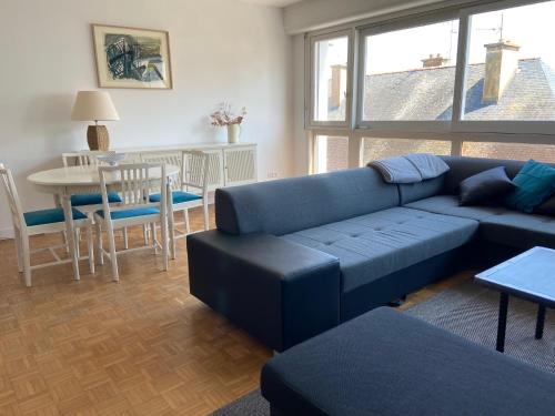 un salon avec un canapé bleu et une table dans l'établissement Appartement de ville et plage, à Concarneau