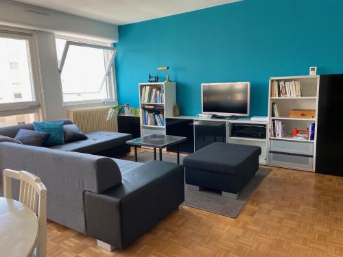 un salon avec un canapé et une télévision dans l'établissement Appartement de ville et plage, à Concarneau