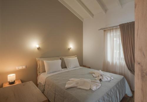 Un dormitorio con una cama con dos toallas encima. en Angela's House, en Centro histórico de Alónnisos