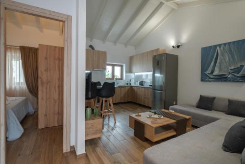 ein Wohnzimmer mit einem Sofa und einem Tisch sowie eine Küche in der Unterkunft Angela's House in Alonnisos Altstadt