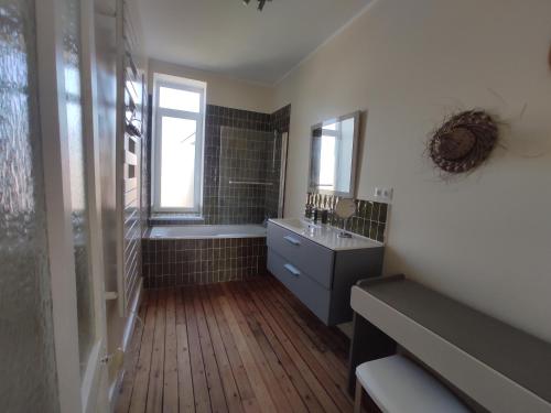 a bathroom with a shower and a sink and a tub at L'ancrage in Wimereux