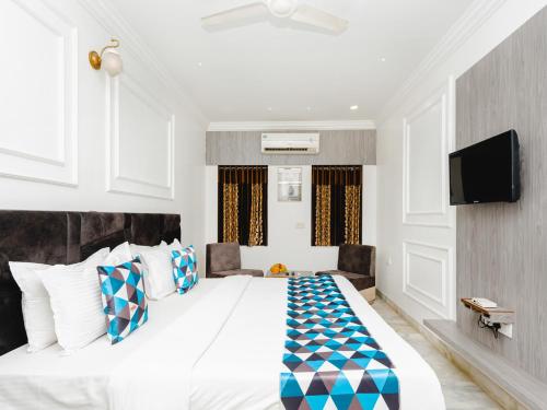 a bedroom with a large bed and a flat screen tv at Hotel Galaxy Opp Surat Railway Station in Surat