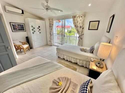 a hotel room with two beds and a balcony at Villa 218E Jolly Harbour in Jolly Harbour