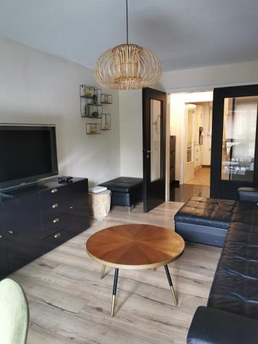 a living room with a table and a couch at appartement cosy à 10 min du centre de Strasbourg in Strasbourg