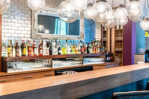 a bar in a restaurant with a mirror and lights at Premier Inn Heidelberg City Centre in Heidelberg