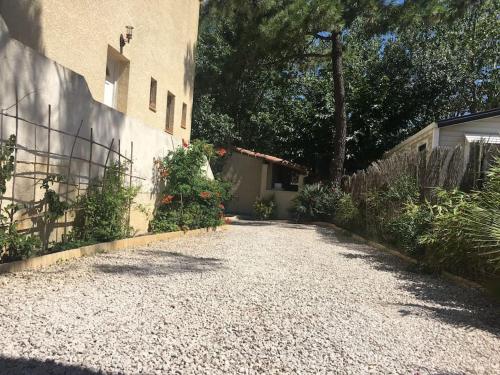 une allée en gravier en face d'une maison dans l'établissement Marseillan Plage studio indépendant, à Marseillan