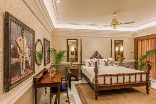 a bedroom with a bed and a table and a desk at Raajkutir - IHCL SeleQtions in Kolkata