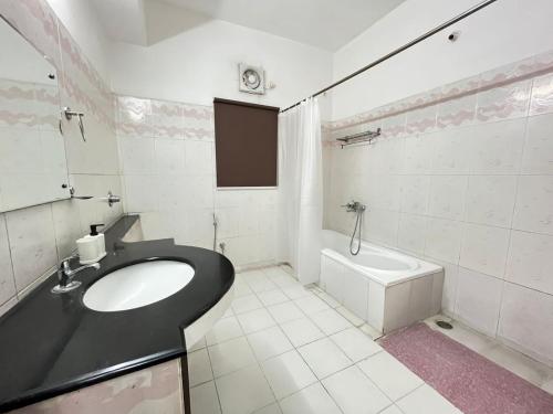 a bathroom with a sink and a bath tub at BedChambers Serviced Apartments in Hyderabad