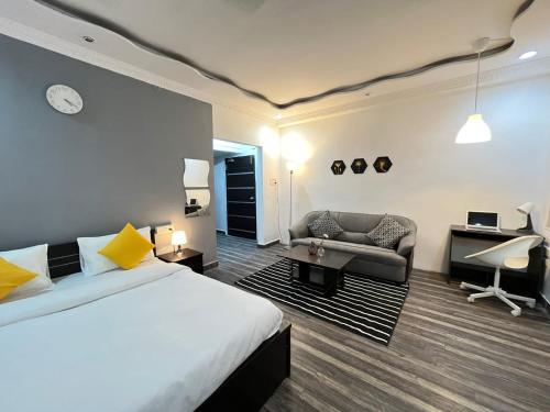 1 dormitorio con cama, sofá y escritorio en BedChambers Serviced Apartments en Hyderabad