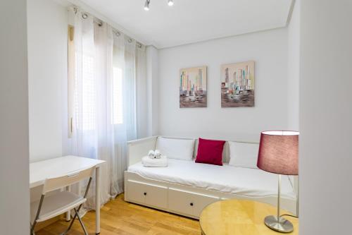 a white bedroom with a bed and a desk at Cituspace Las Tablas - Grañón in Madrid