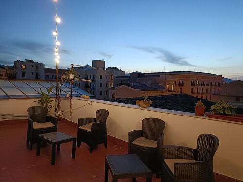 a balcony with chairs and tables and a view of a city at Mille Lire in Palermo