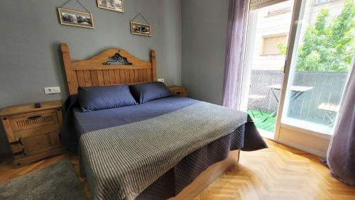 een slaapkamer met een bed en een groot raam bij El Hogar de Todos in Ourense
