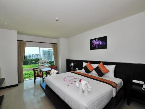a bedroom with a large bed with white sheets at H.R.K.Resort in Patong Beach