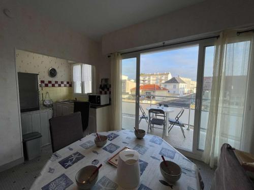 une chambre avec une table et une cuisine avec un balcon dans l'établissement Studio alcôve 4 pers à 50m de la plage avec balcon et cave vélos, Saint-Jean-de-Monts - FR-1-224C-448, à Saint-Jean-de-Monts