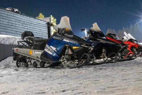 una motoslitta parcheggiata nella neve accanto a un edificio di Lomahuoneisto Suomukas 6 B a Suomutunturi