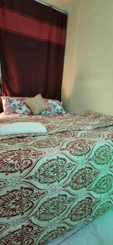 ein Bett in einem Schlafzimmer mit einer Bettdecke darauf in der Unterkunft Exotic land in Abu Dhabi