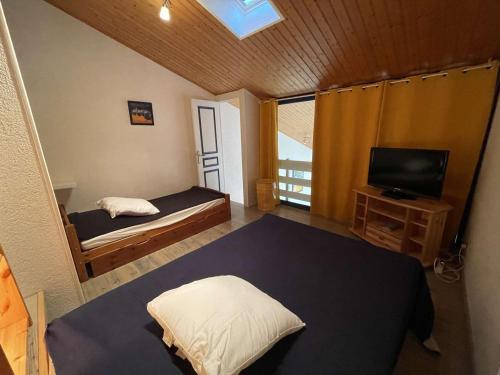 Cette petite chambre comprend un lit et une télévision. dans l'établissement Studio Mezzanine 4 Pers, Plage à 50m, Parking Privé - FR-1-224C-591, à Saint-Jean-de-Monts
