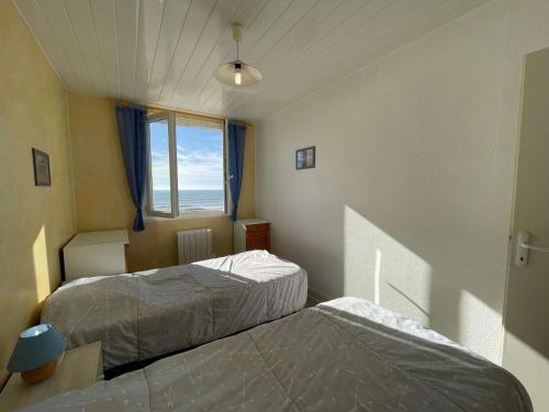 deux lits dans une chambre avec une fenêtre dans l'établissement Appartement 3 pièces Saint-Hilaire-de-Riez, 50m plage, parking, animaux admis - FR-1-224C-616, à Saint-Hilaire-de-Riez