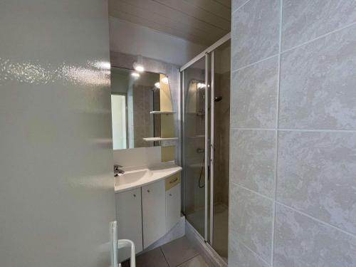 une salle de bain avec un lavabo et une douche avec un miroir dans l'établissement Appartement 3 pièces Saint-Hilaire-de-Riez, 50m plage, parking, animaux admis - FR-1-224C-616, à Saint-Hilaire-de-Riez
