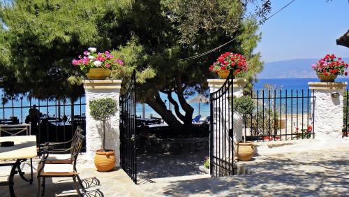 a wrought iron gate with flowers on it next to the ocean at Four Seasons Hydra Luxury Suites in Hydra