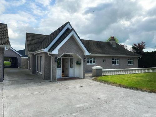 a house with a driveway in front of it at Rooms at Ballysax House in The Curragh