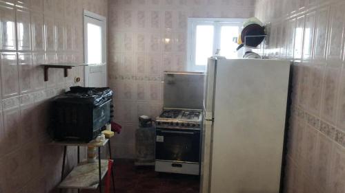 eine kleine Küche mit einem Herd und einem Kühlschrank in der Unterkunft قريه رمسيس الساحل الشمالي الكيلو ٤٥ in Dawwār Abū Maḩrūs