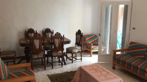 ein Wohnzimmer mit einem Esstisch und Stühlen in der Unterkunft قريه رمسيس الساحل الشمالي الكيلو ٤٥ in Dawwār Abū Maḩrūs