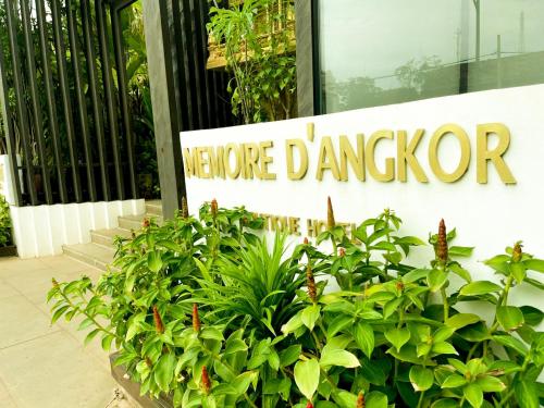 a sign in front of a building with plants at Memoire d' Angkor Boutique Hotel in Siem Reap