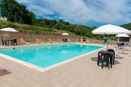 uma grande piscina com cadeiras e guarda-sóis em Villa Aurora em Monte Rinaldo