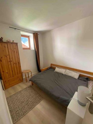 une chambre avec un lit, une table et une fenêtre dans l'établissement Marmot, coeur montagne, Serre Chevalier, Col de l'Izoard, à Cervières