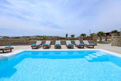 una piscina con tumbonas y una piscina en The George Villas Mykonos with Private Pool & Town Proximity, en Mykonos ciudad