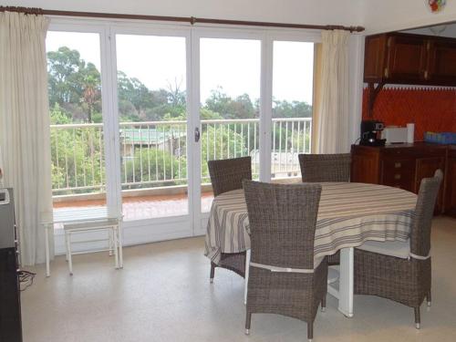 une salle à manger avec une table, des chaises et des fenêtres dans l'établissement Charmant appartement climatisé, parking, animaux admis - FR-1-100-221, à Cavalaire-sur-Mer