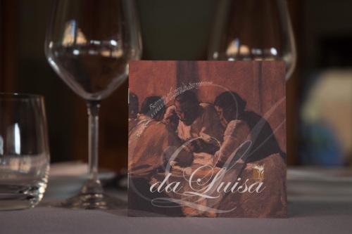 a card on a table with a glass of wine at Casa Di Mi in Serrungarina