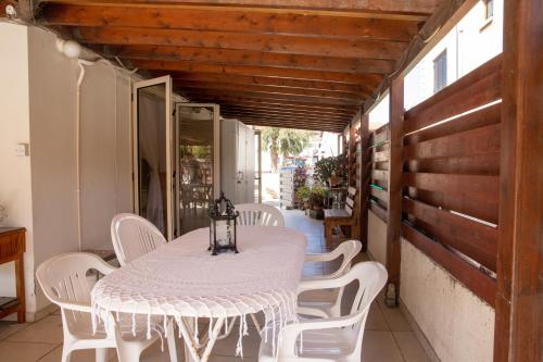 a white table and white chairs on a porch at Spyros No23 Charming Oceanview Maisonette in Meneou