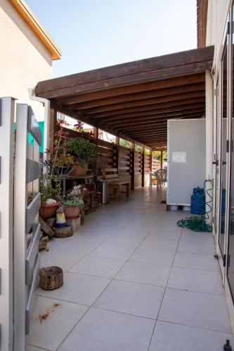 an outdoor patio with awning and tables and potted plants at Spyros No23 Charming Oceanview Maisonette in Meneou
