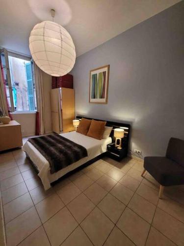 une chambre avec un lit, une chaise et une lampe dans l'établissement Vieux Nice Vibrant Central Apt, à Nice