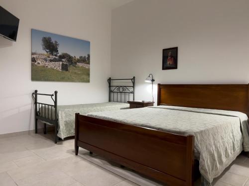 a bedroom with two beds and a television in it at Agriturismo Torre del Cardo in Torre Lapillo